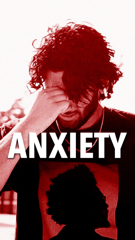 A person with dark curly hair and a beard covers their face with one hand, with the word ANXIETY emblazoned in white across the stark red and white image.